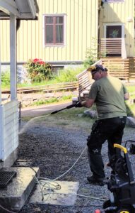 Man spolar av en träveranda